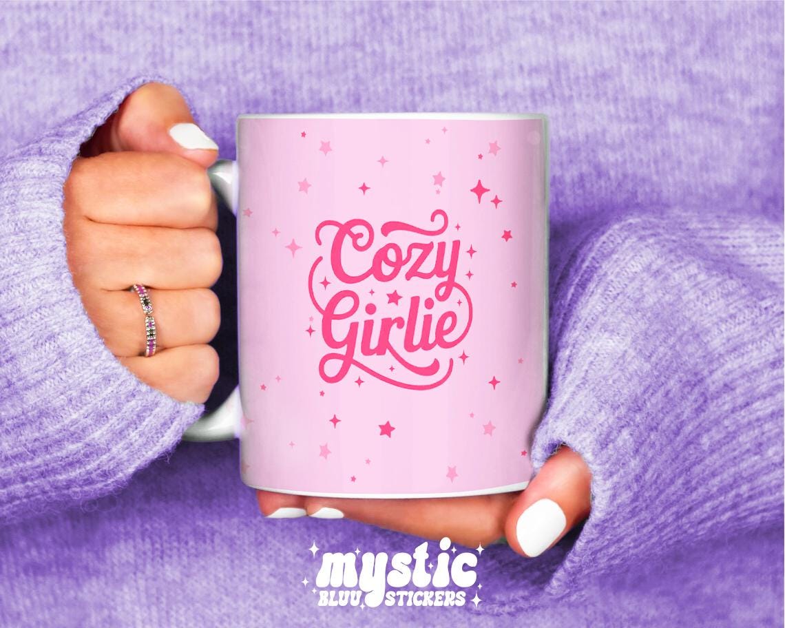 Pink Cozy Girlie coffee mug with stars, held in hands wearing a lavender sweater.